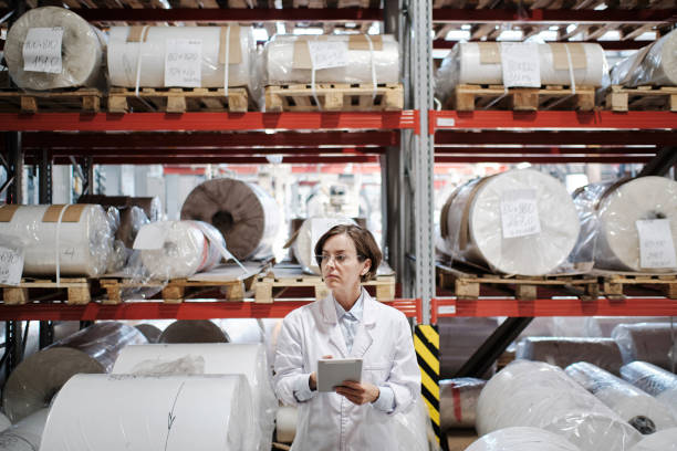 istock Executive woman in robe using tablet at factory 1354611140