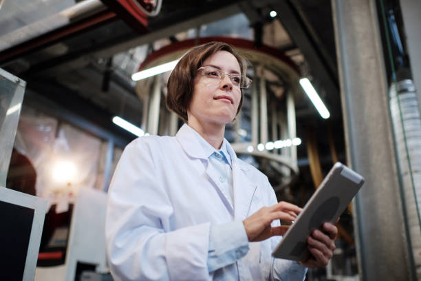 istock Woman factory worker using tablet 1354611335
