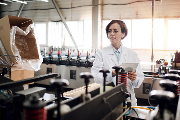 istock Female executive working at factory with machines 1354611878