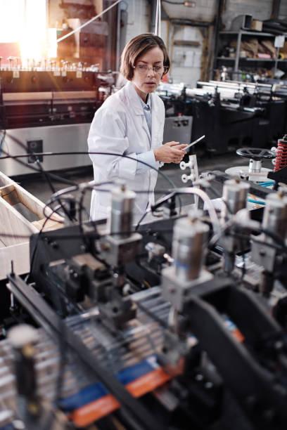 Female executive working at factory with machines