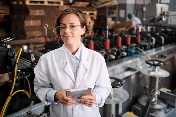 Female executive working with tablet, checking factory machines