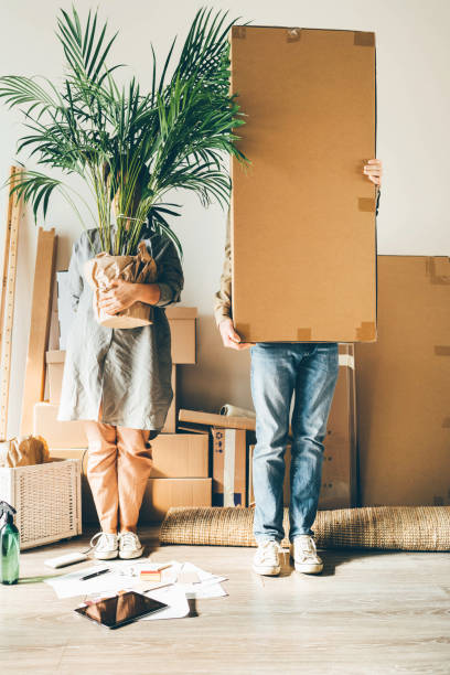 Joyful family carries boxes with belongings in new house stock photo