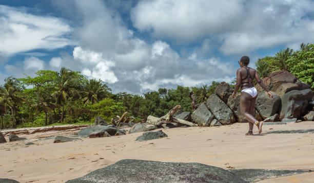 istock African woman walking on an empty beach 1354614227