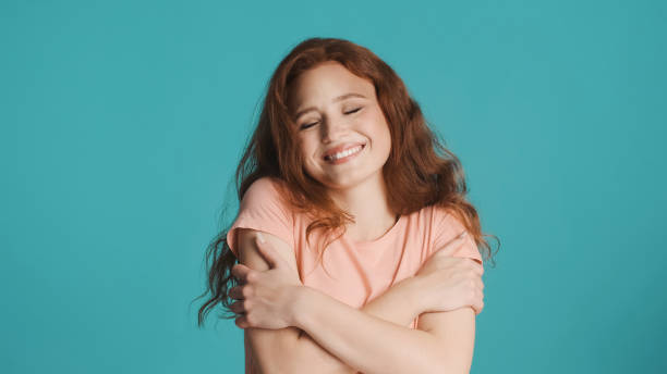 istock Pretty charming redhead girl cutely posing on camera over colorful background. Happy expression 1354614481