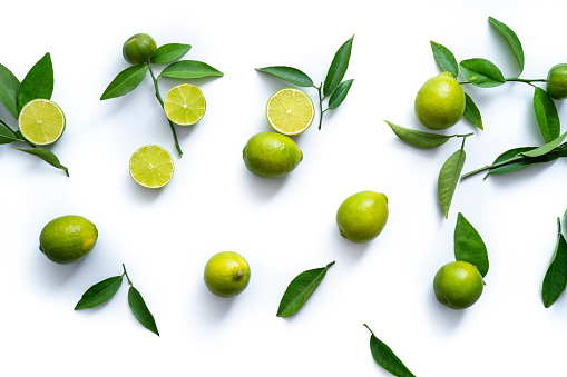 Fresh ripe lemons, limes and mint leaves on wooden background, flat lay