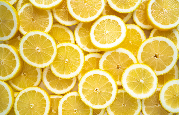 zitronenfruchtscheiben anordnung in einer reihe vollbildhintergrund - lemon stock-fotos und bilder