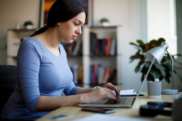 istock Young woman using laptop for working at home 1354626353
