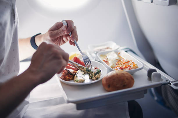 istock Passenger eating airline meal in airplane 1354628481