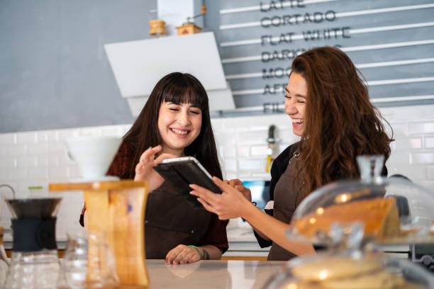 istock Two female barista having a conversation and using tablet at coffee shop 1354640856