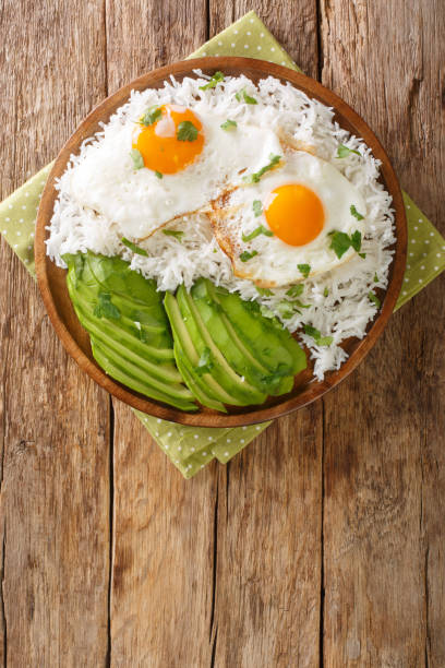 istock Ecuadorian simple breakfast of boiled rice and fried eggs close-up in a plate. vertical top view 1354641409