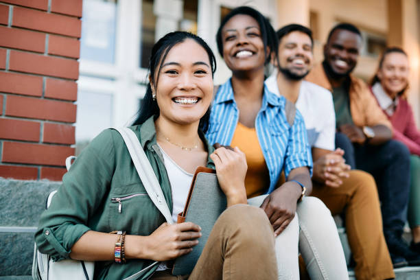 istock Group of happy multiracial students relaxing at campus and looking at camera. 1354641565