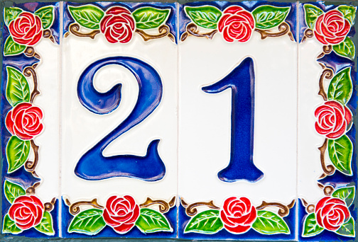 Tiles decorated with a floral pattern with the house number Twenty-One