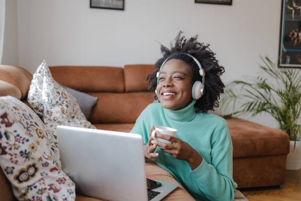 istock Young African American woman is working from home on laptop while drinking coffee 1354651426