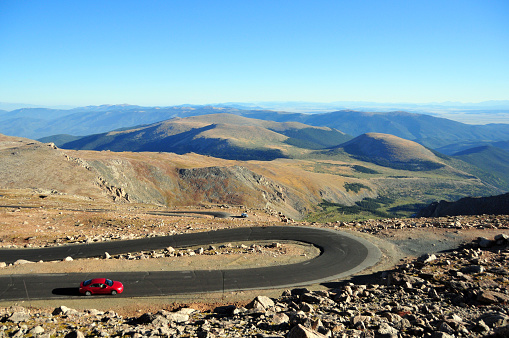 Mount Evans, Clear Creek County, Front Range of the Rocky Mountains, Colorado, USA: a car enters a switchback on the Mount Evans Scenic Byway. The road begins in Idaho Springs at the I-70, using State Highway 103 and continues on State Highway 5 to the summit of Mount Evans. The Scenic Byway climbs more than 2,000 meters from its starting point and is the highest paved road in the United States (4,307 meters at the top).