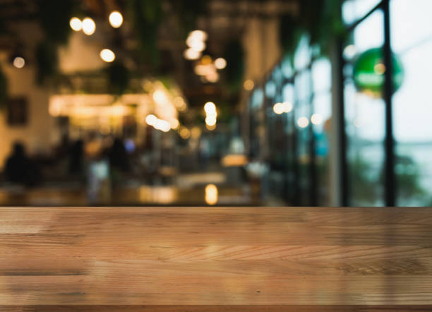 istock Empty wooden table top with lights bokeh on blur restaurant background. 1354656712