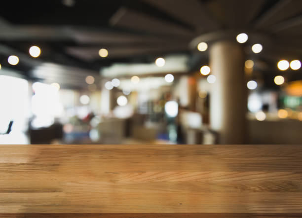 istock Empty wooden table top with lights bokeh on blur restaurant background. 1354656714