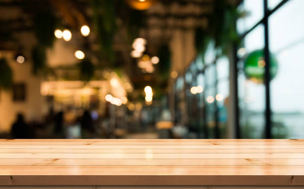 istock Empty wooden table top with lights bokeh on blur restaurant background. 1354660673