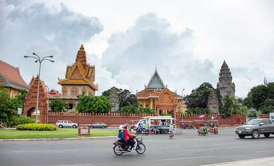 Traffic in front of Wat Ounalom in the river front area of Phnom Penh, Cambodia.