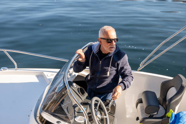 istock Mature man piloting boat on lake in Autumn 1354670880