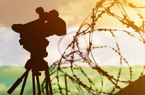 istock Double exposure - camera, barbed wire and flag India 1354673645