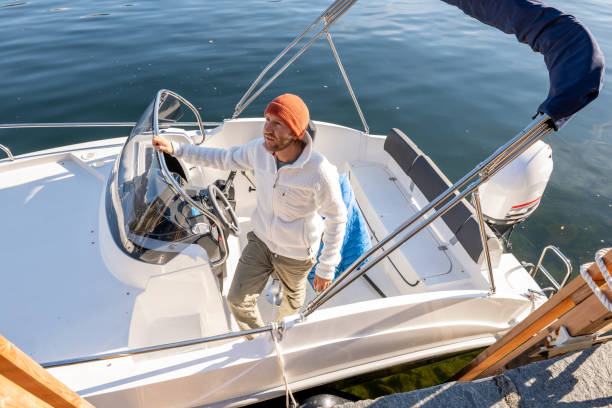 istock Young man disembarking from boat on lake in Autumn 1354674744