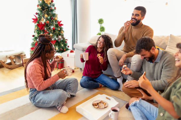 freunde, die kaffee trinken und lebkuchenplätzchen essen, während sie weihnachten feiern - communication discussion coffee christmas stock-fotos und bilder