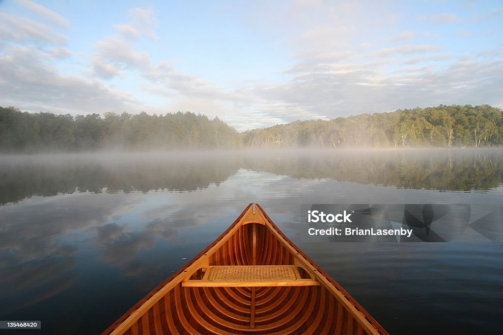 Journey by Cedar Canoe Bow of a cedar canoe being paddled on a northern Ontario lake Ontario - Canada Stock Photo