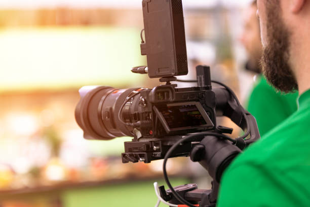 istock Videographer shooting a film or a television program in a studio with a professional camera, backstage 1354688360