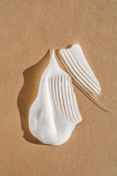 The texture of the white cream on a beige background.