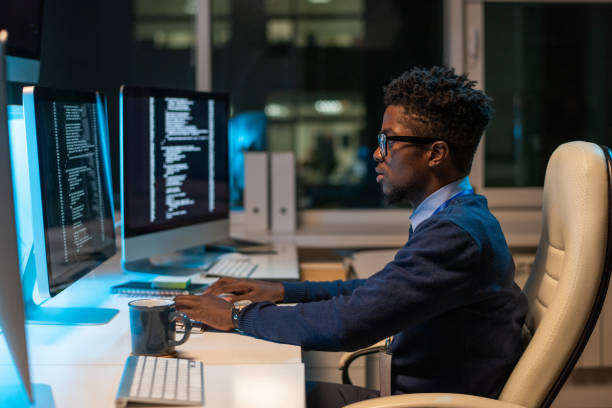 istock Young it-engineer of African ethnicity working in front of computer 1354692508