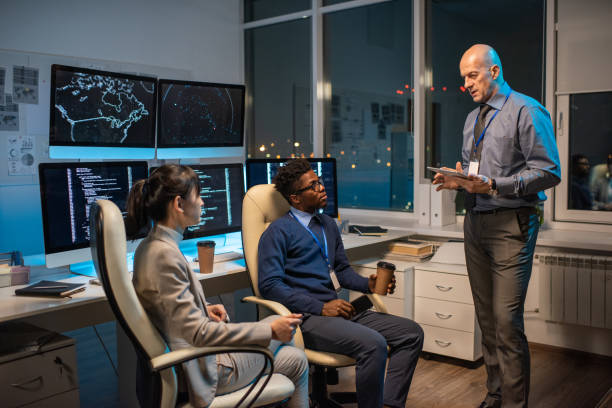 istock Confident mature manager with tablet interacting with two young subordinates 1354692588
