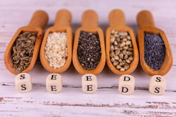 istock Useful assorted seeds in wooden scoops on a white background. 1354693051