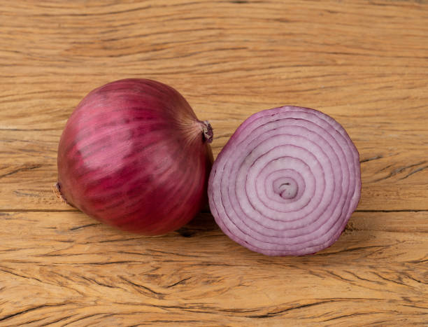 istock Purple or red onion and a half over wooden table 1354693442