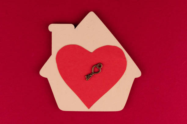 istock Small house with a red heart and a key on a red background. 1354694143