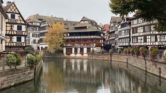 Strasbourg, France – October 16, 2021: Traditional wooden patterned houses on a canal in the downtown of Strasbourg.