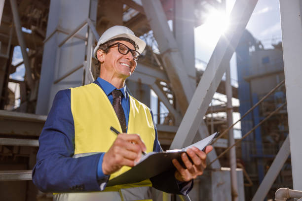 istock Cheerful male engineer writing documents outdoors at factory 1354697156