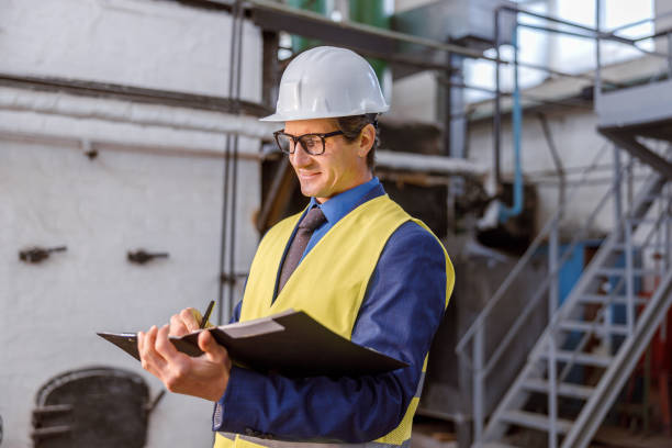 istock Cheerful male engineer writing documents at factory 1354697207
