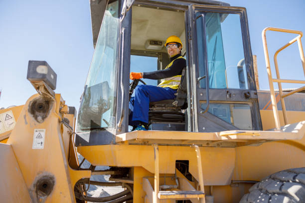 istock Joyful matured man sitting in tractor at factory 1354697227