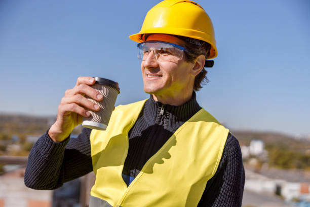 istock Joyful man factory worker drinking coffee outdoors 1354697316