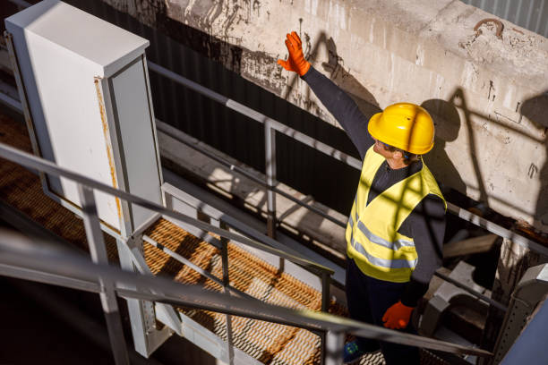 istock Male engineer standing on metal bridge at factory 1354697334