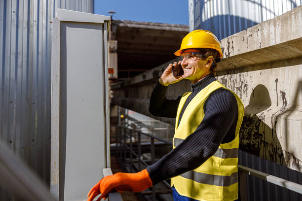 istock Joyful male engineer talking on mobile phone at factory 1354697343