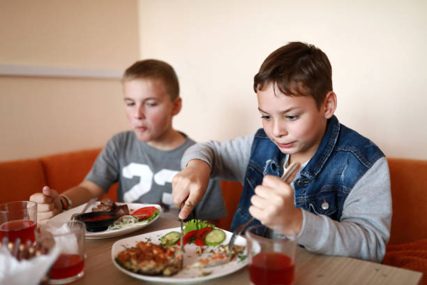 istock Two kids have lunch in restaurant 1354698269
