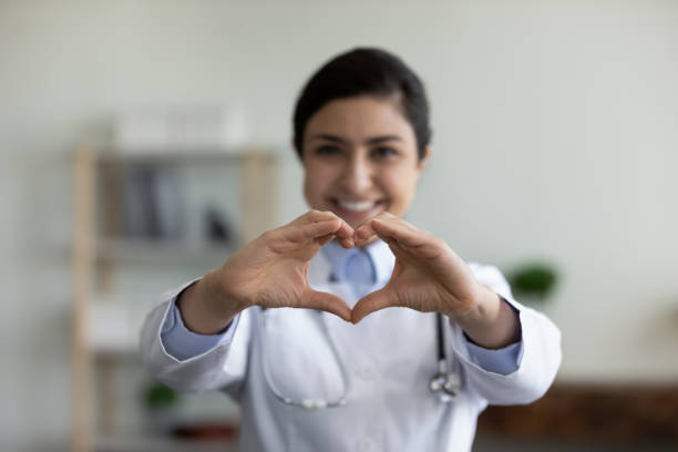 istock Happy Indian GP doctor showing finger heart shape at camera 1354699708