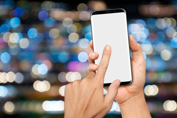 istock Hand holding and touching on a big screen Smartphone with night bokeh background 1354700237