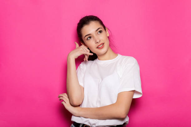 istock Cheerful woman makes call gesture, dressed in casual pullover 1354704216