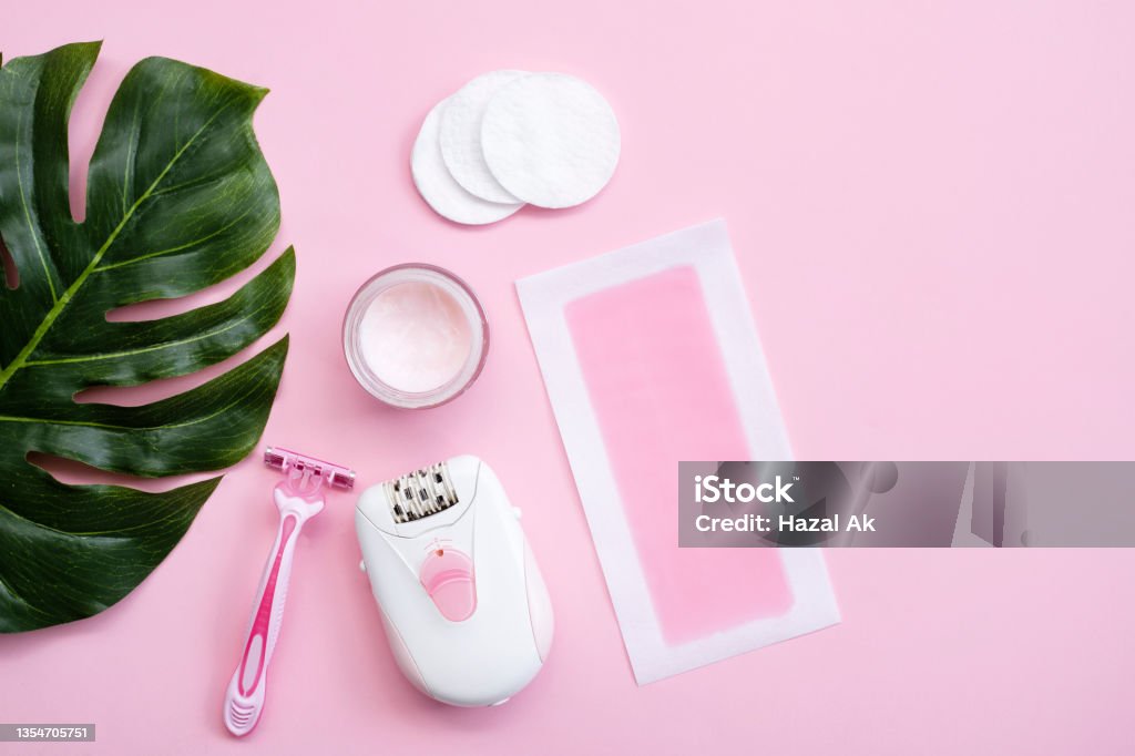 Pink epilator with wax strips and razor for removal of unwanted hair. Flat lay Epilator Stock Photo