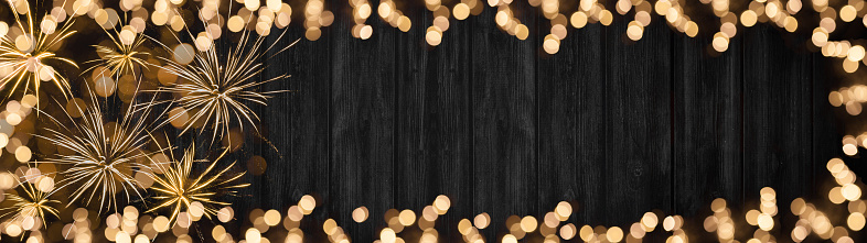 Frame of lights bokeh golden flares, isolated on rustic black wooden texture - Holiday New Year's Eve Silvester New Year Party Christmas festive background banner panorama greeting card
