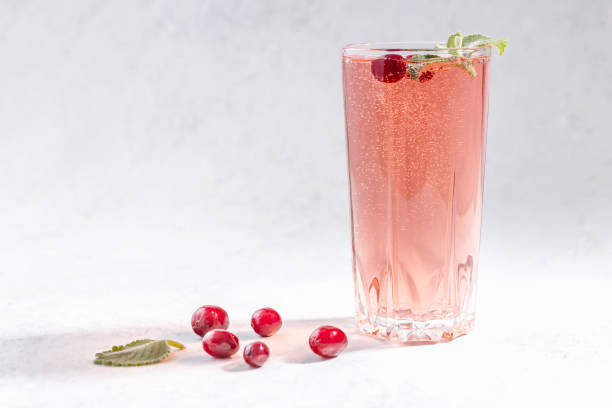 bicchiere di acqua seltzer con mirtilli rossi e foglia di menta - cranberry juice foto e immagini stock