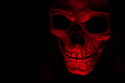 Scary grunge skull, horror wallpaper with spooky skull in red light, Halloween.