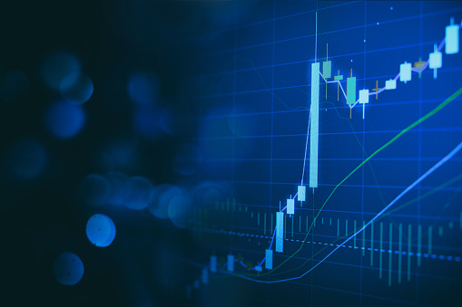 Close up financial chart with uptrend line graph in stock market on defocused blue colour bokeh background